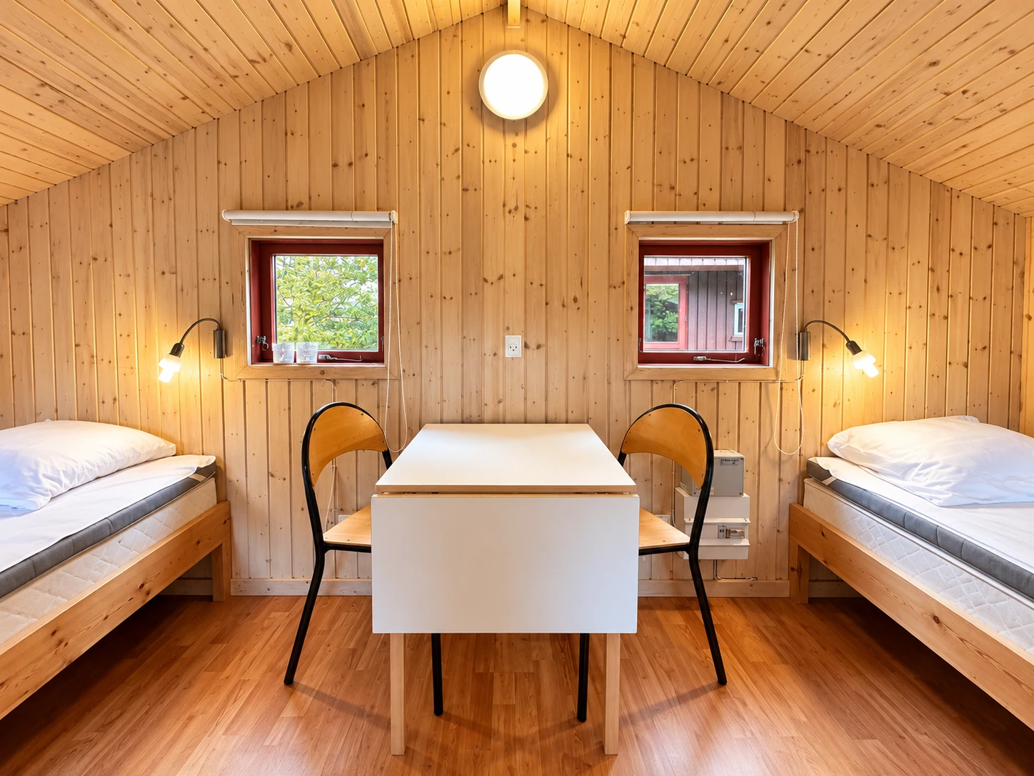 Cykelhytte – interior Two beds with a small table in the Cykelhytte