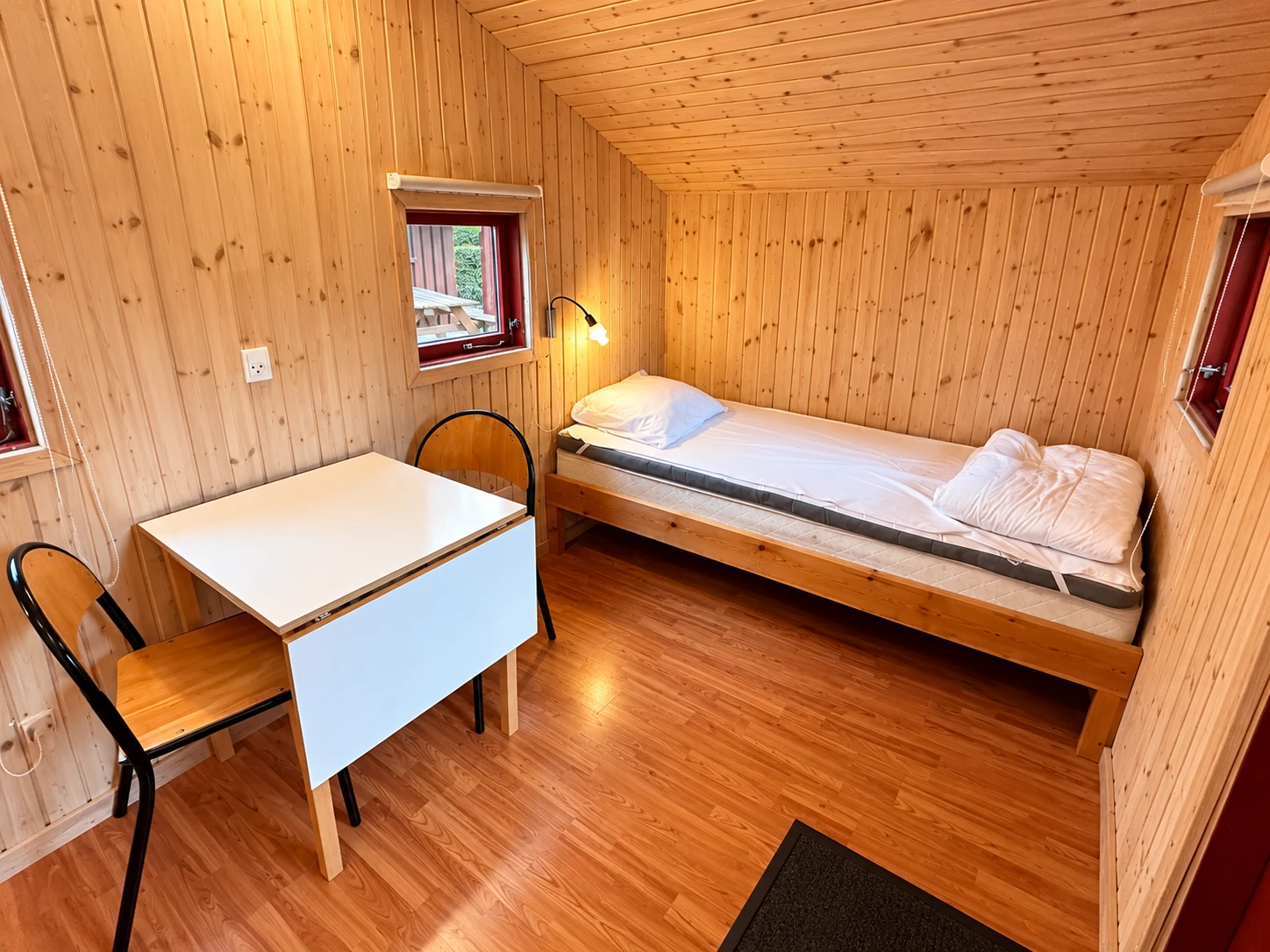 Cykelhytte – interior View into the Cykelhytte with bed, table and chairs