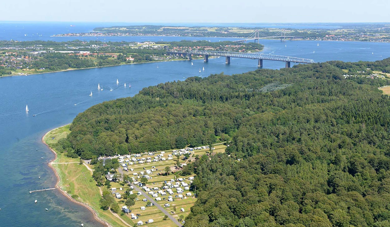 Luftaufnahme vom Galsklint Strand Camping am Kleinen Belt mit den Kleiner-Belt-Brücken im Hintergrund.