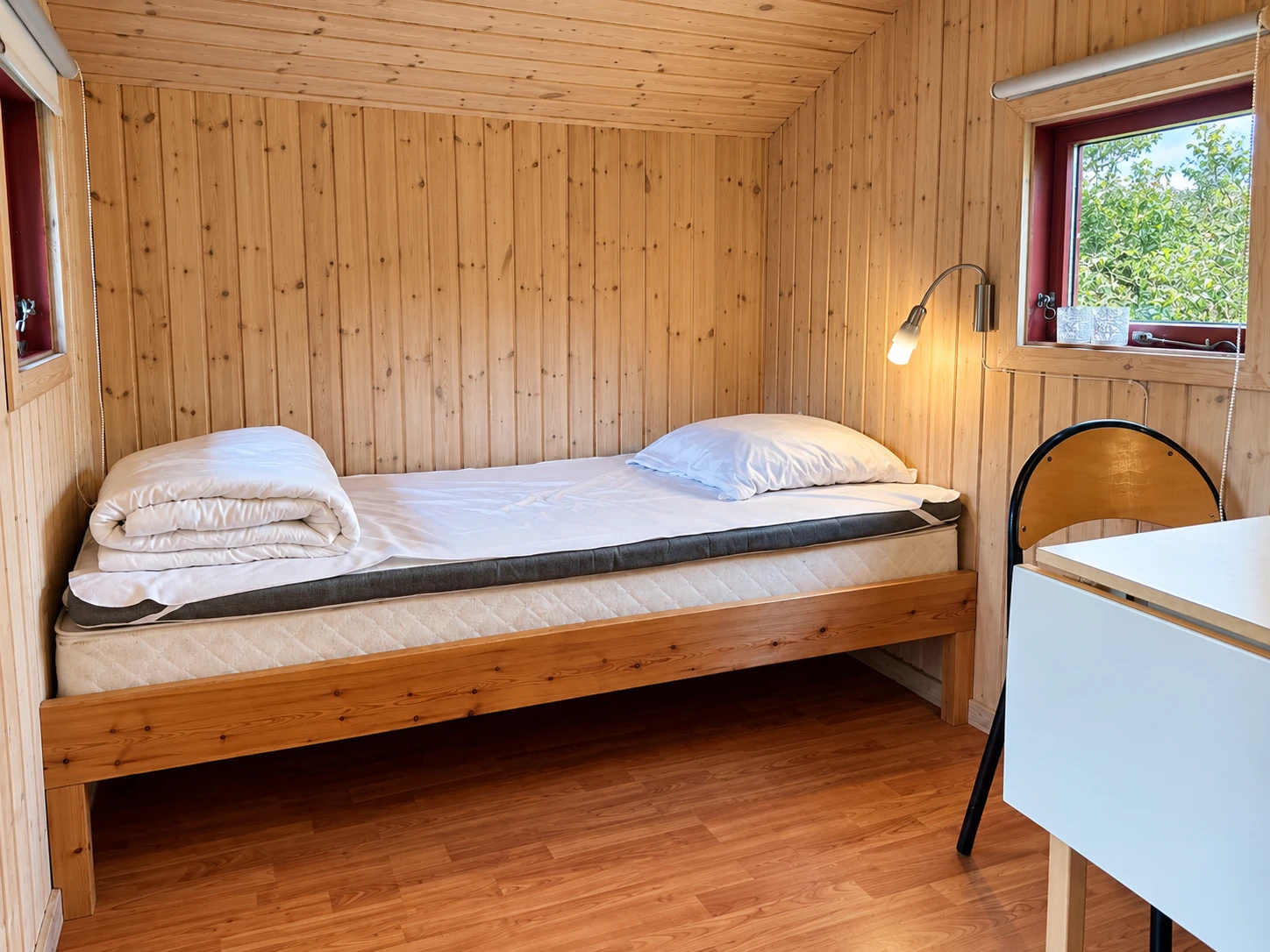 Cykelhytte – sleeping area Bed with reading lamp in the Cykelhytte