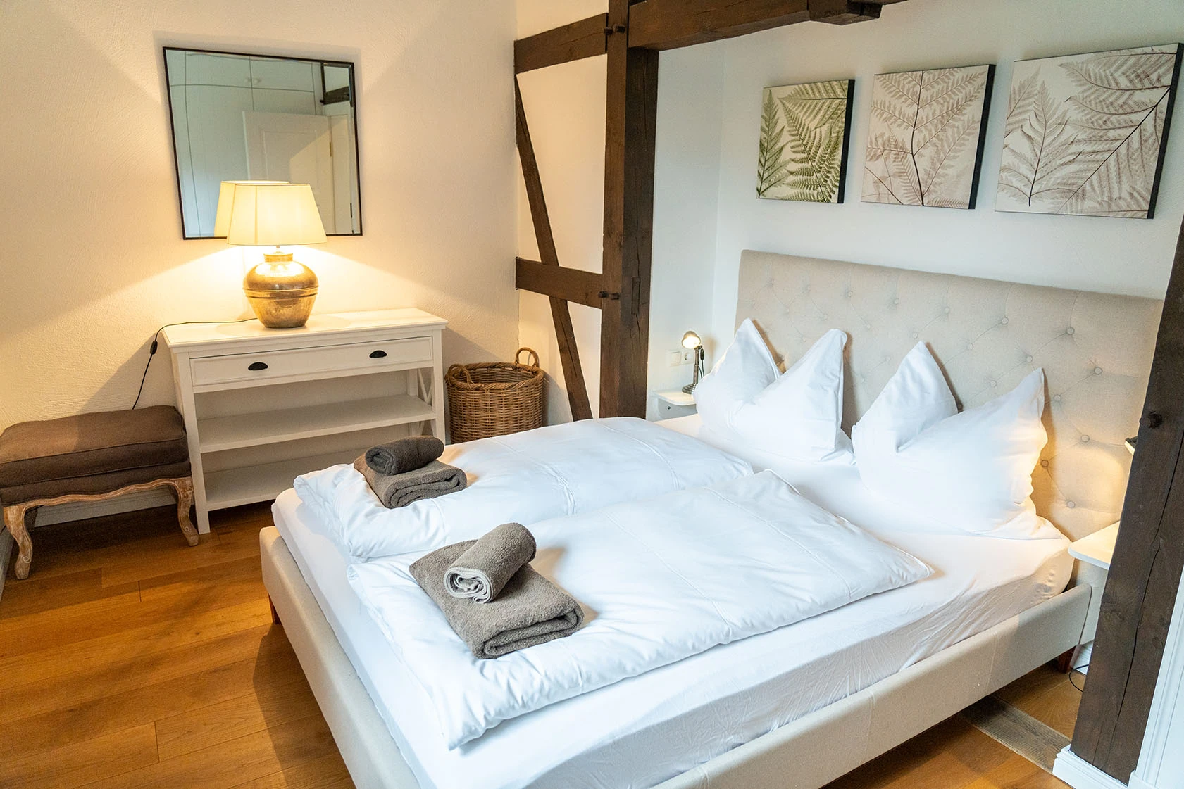 Bett und Kommode im Schlafzimmer vom Apartment 2 des Hofguts Bockelkathen